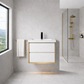 Modern bathroom with a white vanity, gold fixtures, and a view of greenery outside the window.